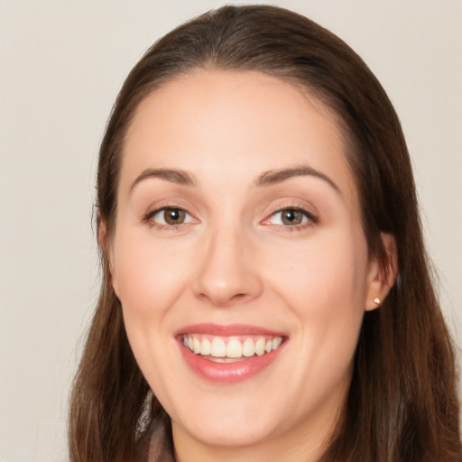 Joyful white young-adult female with long  brown hair and brown eyes