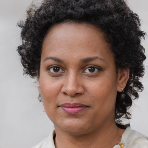 Joyful black adult female with short  brown hair and brown eyes