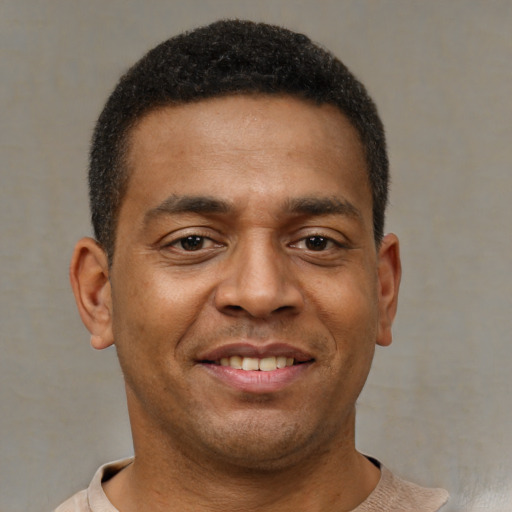 Joyful latino young-adult male with short  brown hair and brown eyes