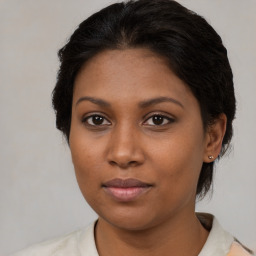 Joyful black young-adult female with medium  brown hair and brown eyes