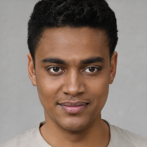 Joyful black young-adult male with short  black hair and brown eyes
