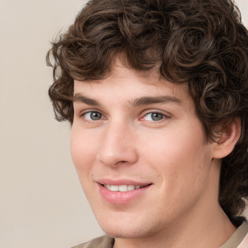 Joyful white young-adult male with medium  brown hair and grey eyes