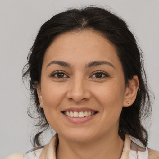 Joyful latino young-adult female with medium  brown hair and brown eyes