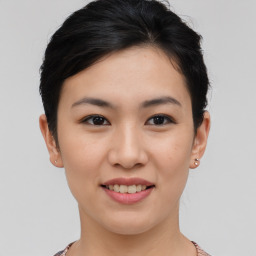 Joyful asian young-adult female with short  brown hair and brown eyes