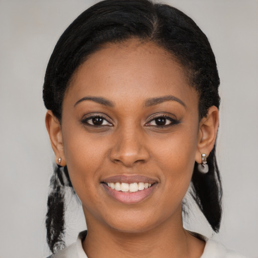 Joyful black young-adult female with medium  black hair and brown eyes