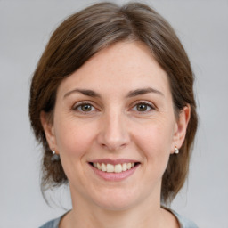 Joyful white young-adult female with medium  brown hair and grey eyes