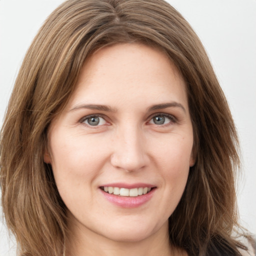 Joyful white young-adult female with long  brown hair and green eyes