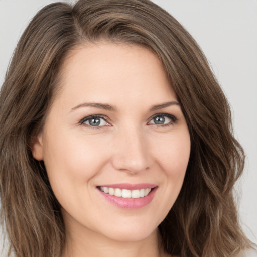 Joyful white young-adult female with long  brown hair and brown eyes