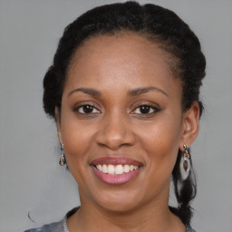 Joyful black adult female with medium  brown hair and brown eyes