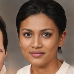 Joyful latino young-adult female with medium  brown hair and brown eyes