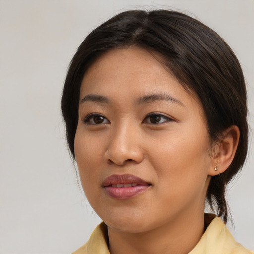 Joyful asian young-adult female with medium  brown hair and brown eyes