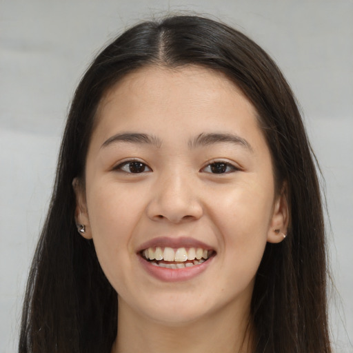Joyful asian young-adult female with long  brown hair and brown eyes