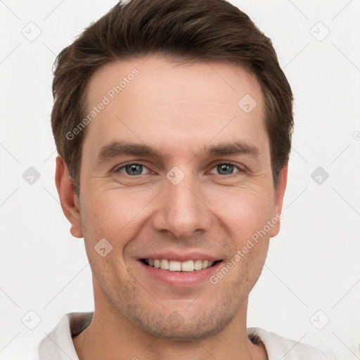 Joyful white young-adult male with short  brown hair and grey eyes