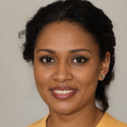 Joyful black young-adult female with medium  brown hair and brown eyes