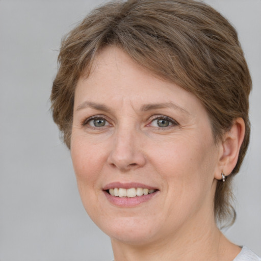 Joyful white adult female with medium  brown hair and grey eyes