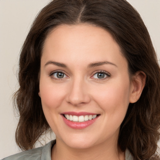 Joyful white young-adult female with medium  brown hair and green eyes