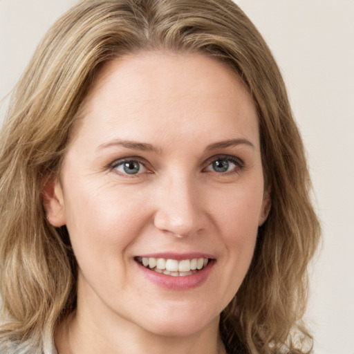 Joyful white young-adult female with medium  brown hair and blue eyes