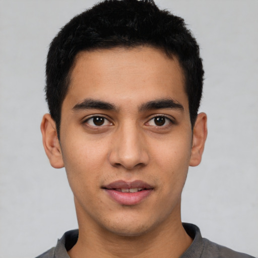 Joyful latino young-adult male with short  black hair and brown eyes