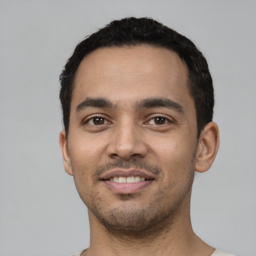 Joyful latino young-adult male with short  black hair and brown eyes