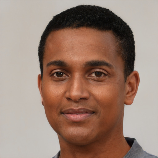 Joyful black young-adult male with short  black hair and brown eyes