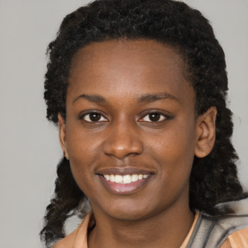 Joyful black young-adult female with medium  black hair and brown eyes