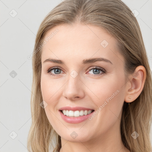 Joyful white young-adult female with long  brown hair and blue eyes