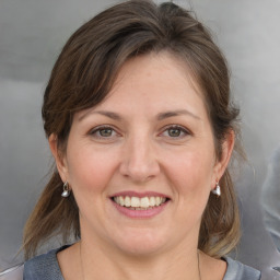 Joyful white adult female with medium  brown hair and grey eyes