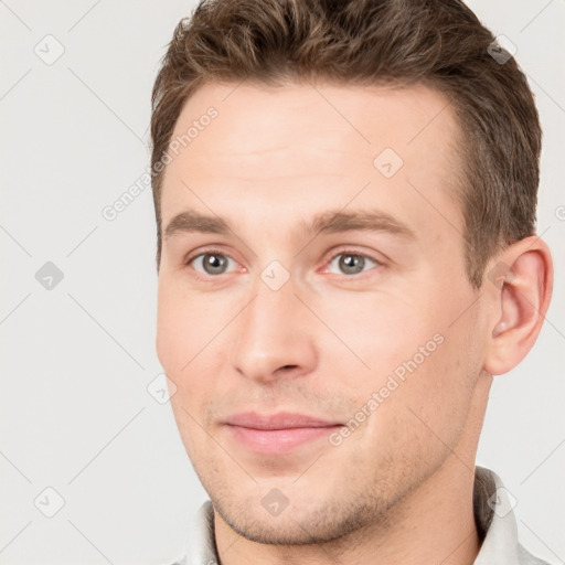 Joyful white young-adult male with short  brown hair and grey eyes