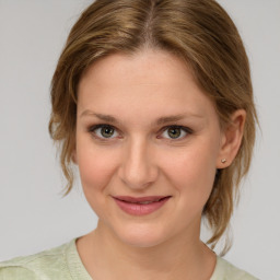 Joyful white young-adult female with medium  brown hair and green eyes