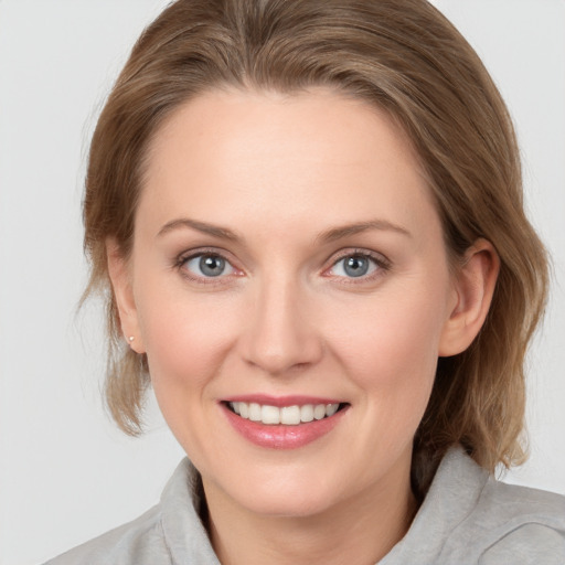 Joyful white young-adult female with medium  brown hair and blue eyes