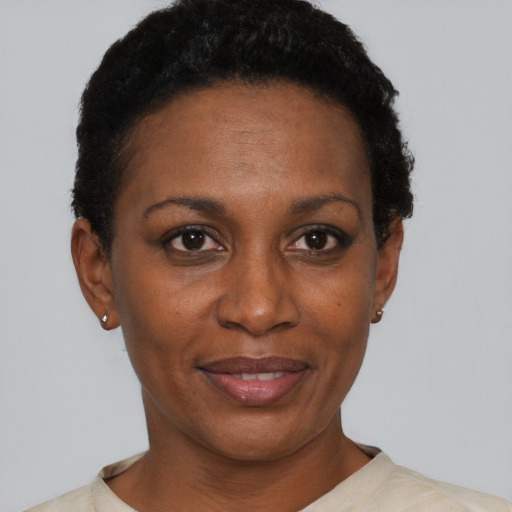Joyful black adult female with short  black hair and brown eyes