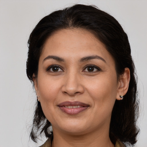 Joyful latino adult female with medium  brown hair and brown eyes