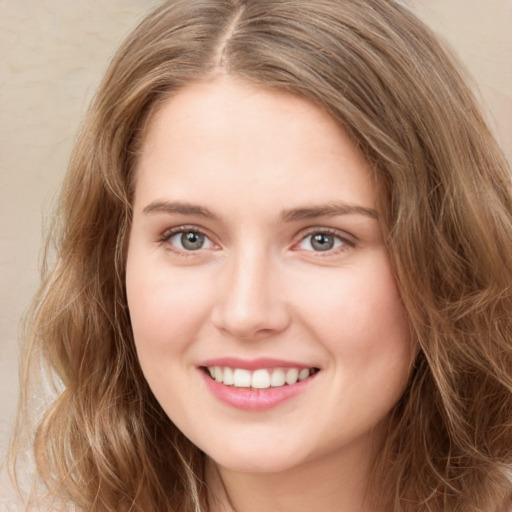 Joyful white young-adult female with long  brown hair and green eyes