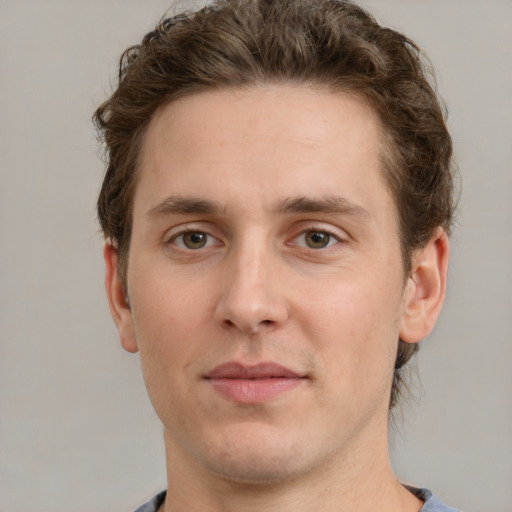 Joyful white young-adult male with short  brown hair and green eyes