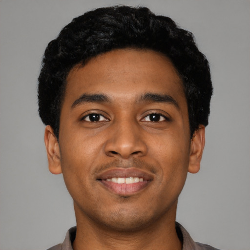 Joyful black young-adult male with short  black hair and brown eyes