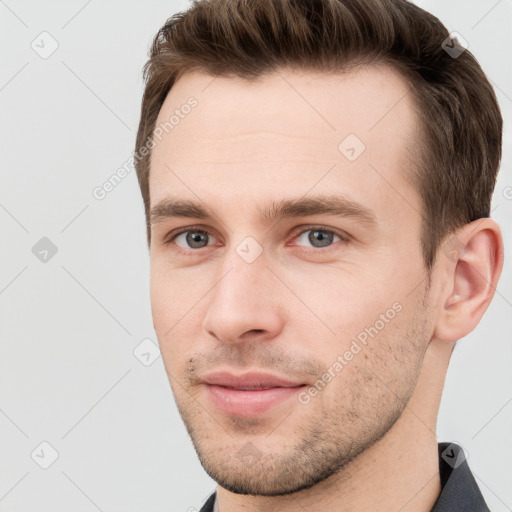 Joyful white young-adult male with short  brown hair and grey eyes