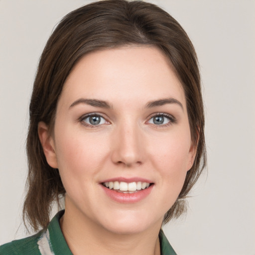 Joyful white young-adult female with medium  brown hair and grey eyes