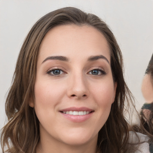 Joyful white young-adult female with long  brown hair and grey eyes