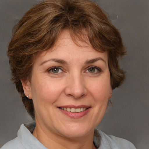 Joyful white adult female with medium  brown hair and blue eyes