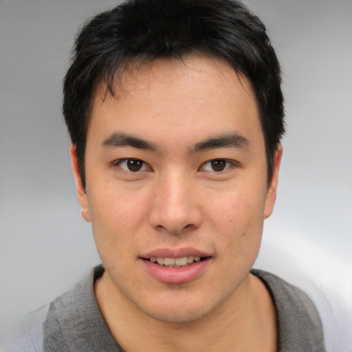 Joyful asian young-adult male with short  brown hair and brown eyes