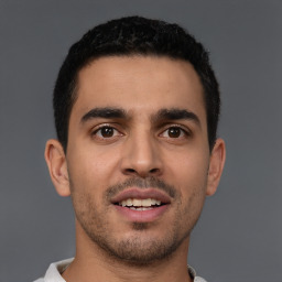 Joyful latino young-adult male with short  brown hair and brown eyes