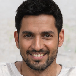 Joyful white young-adult male with short  black hair and brown eyes