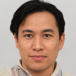 Joyful asian adult male with short  brown hair and brown eyes