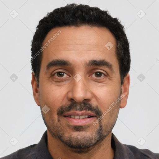 Joyful latino adult male with short  black hair and brown eyes