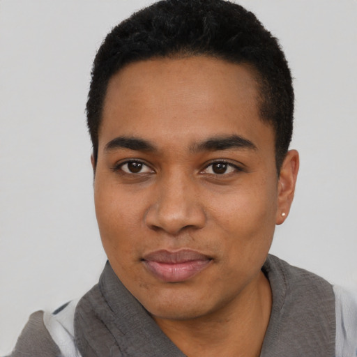 Joyful black young-adult male with short  black hair and brown eyes