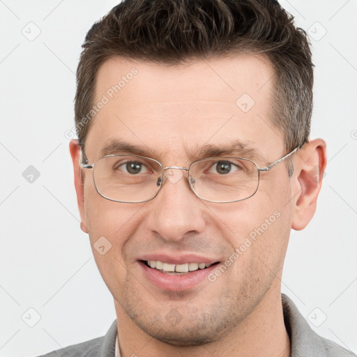 Joyful white adult male with short  brown hair and grey eyes