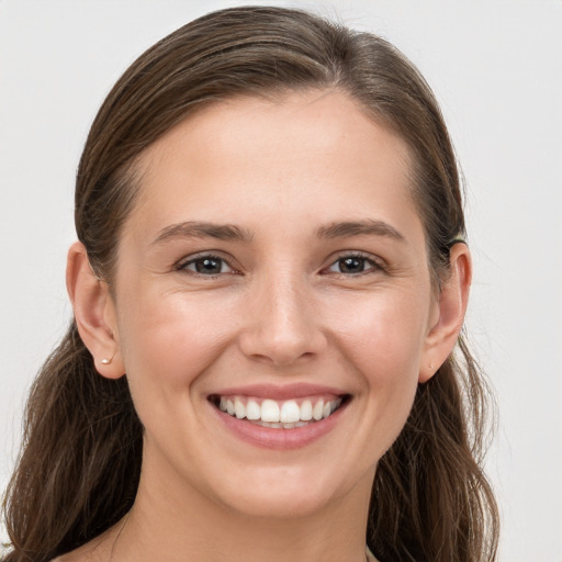 Joyful white young-adult female with long  brown hair and grey eyes