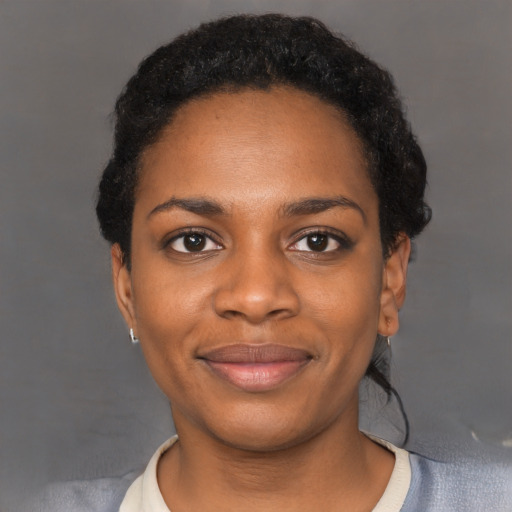 Joyful black young-adult female with short  black hair and brown eyes