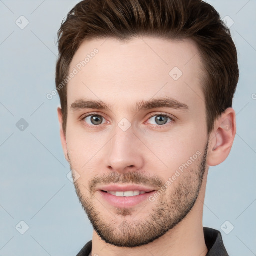 Joyful white young-adult male with short  brown hair and grey eyes