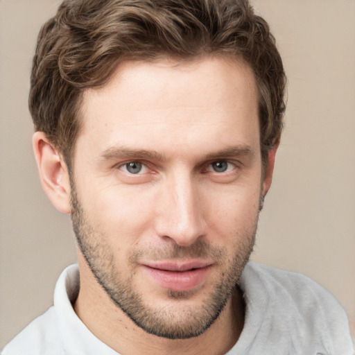 Joyful white young-adult male with short  brown hair and grey eyes